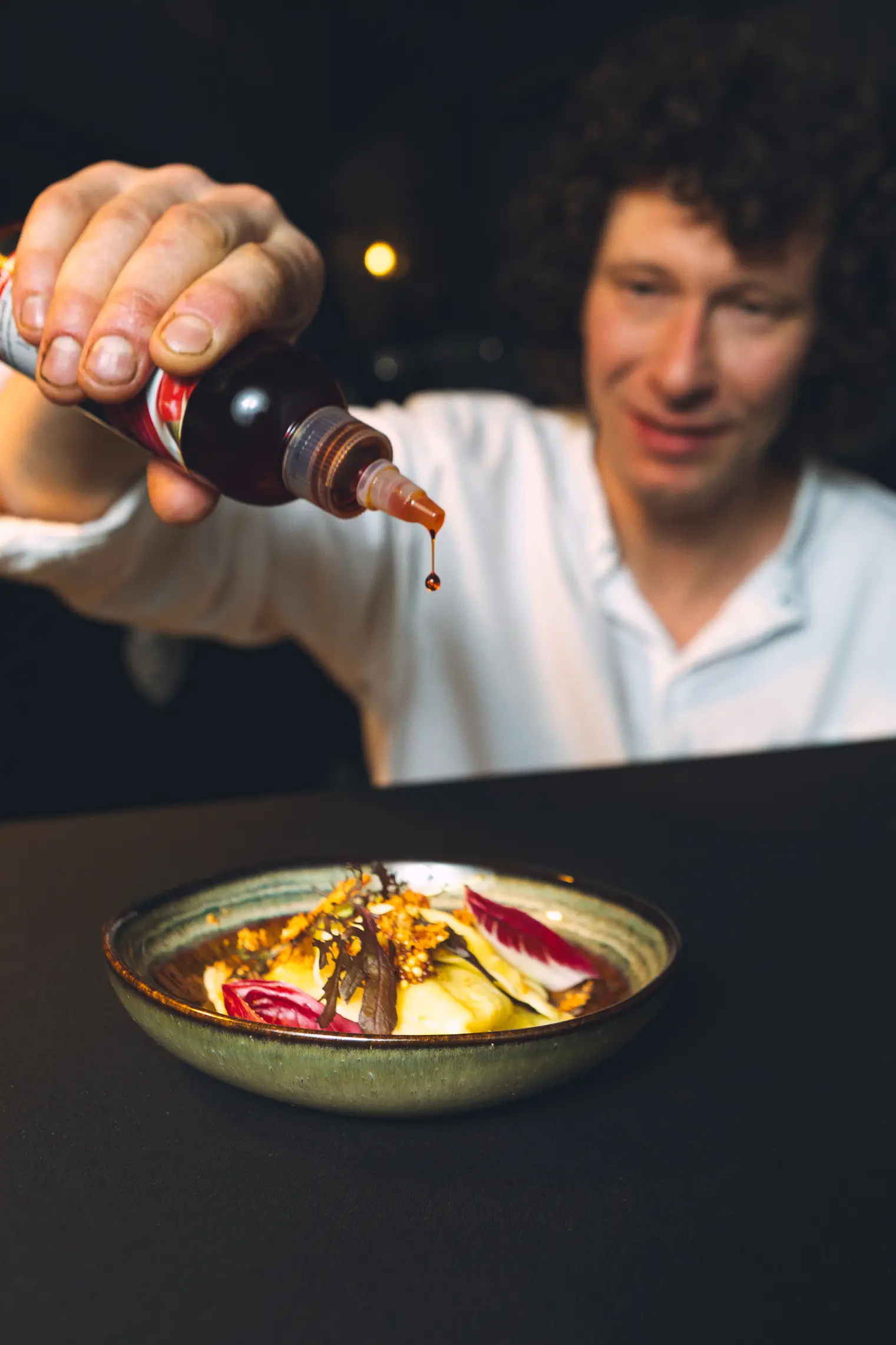Tim maakt een gerecht af met saus