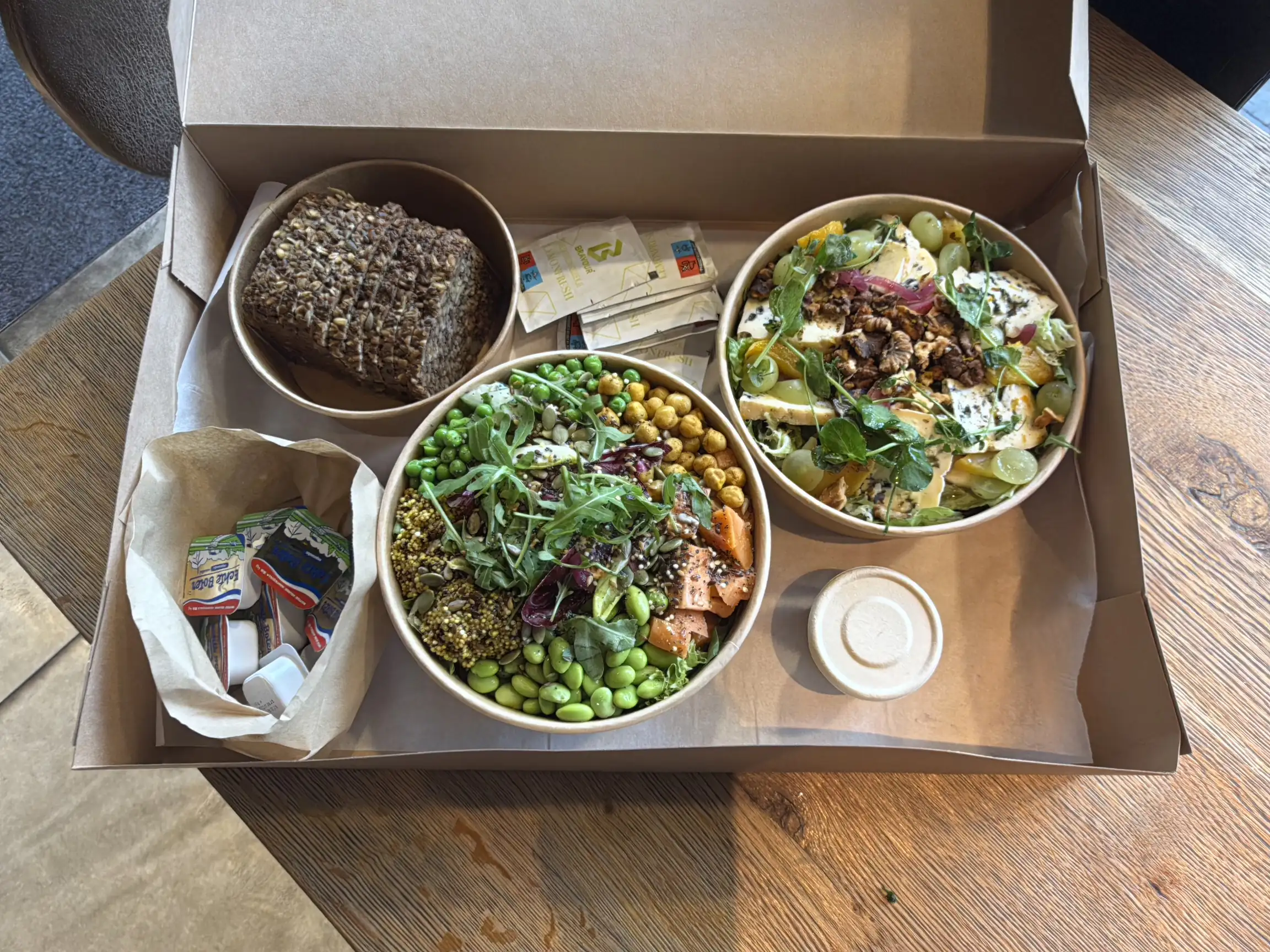 Een complete lunch met salades en brood, klaar om te delen